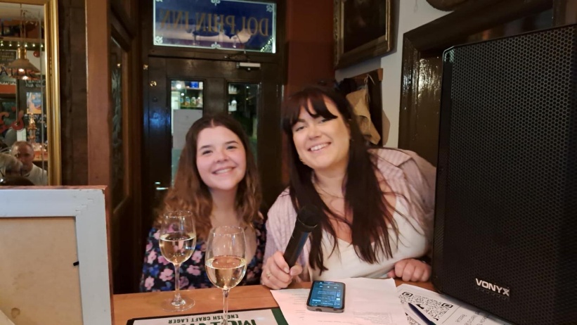Two women sitting at a table with wine glasses

AI-generated content may be incorrect.